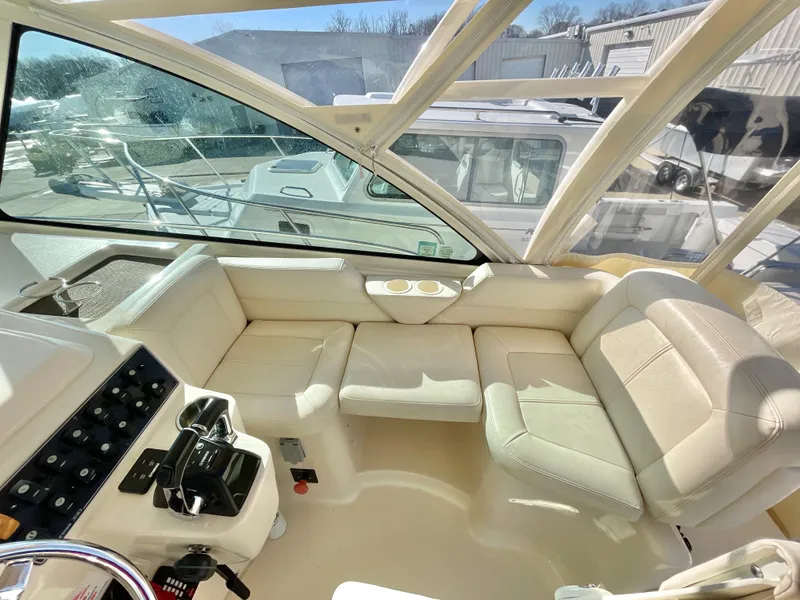 Slide: The Image of 2015 Grady-White Express 330 interior with beige seating and helm controls. - 26