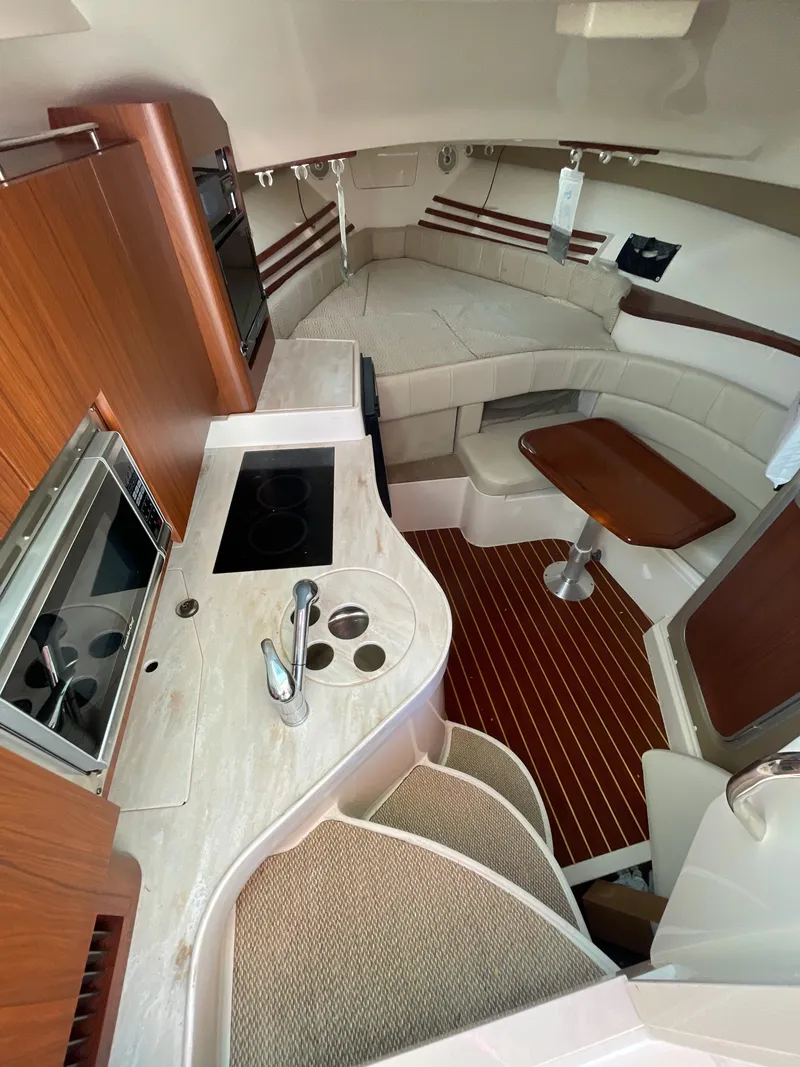 Slide: The Image of 2015 Grady-White Express 330 interior with kitchen, seating, and wood accents. - 28