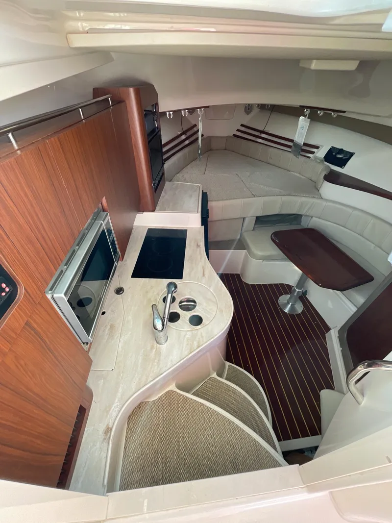 Slide: The Image of 2015 Grady-White Express 330 cabin interior with kitchenette and seating area. - 30