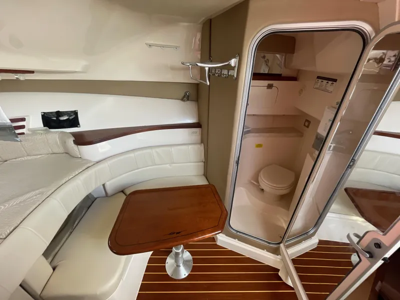 Slide: The Image of 2015 Grady-White Express 330 cabin interior with seating, table, and bathroom. - 32