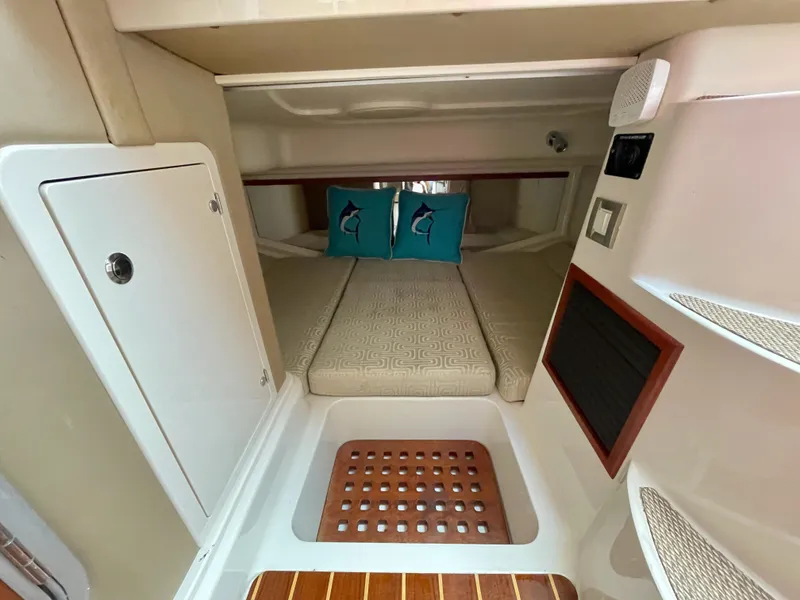 Slide: The Image of 2015 Grady-White Express 330 cabin interior with bed and decorative pillows. - 33