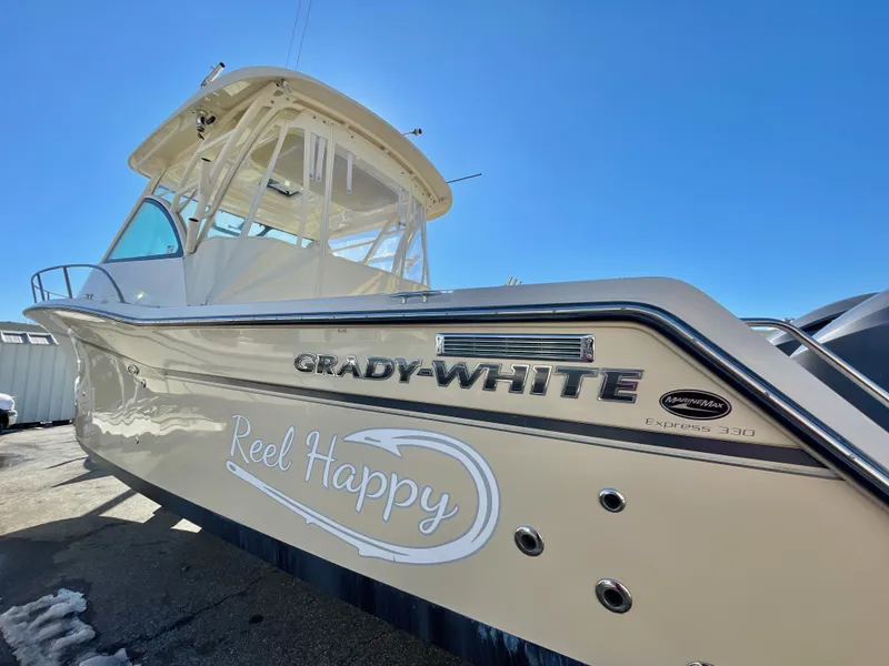 Slide: The Image of 2015 Grady-White Express 330 boat with "Reel Happy" text, sunny day. - 7