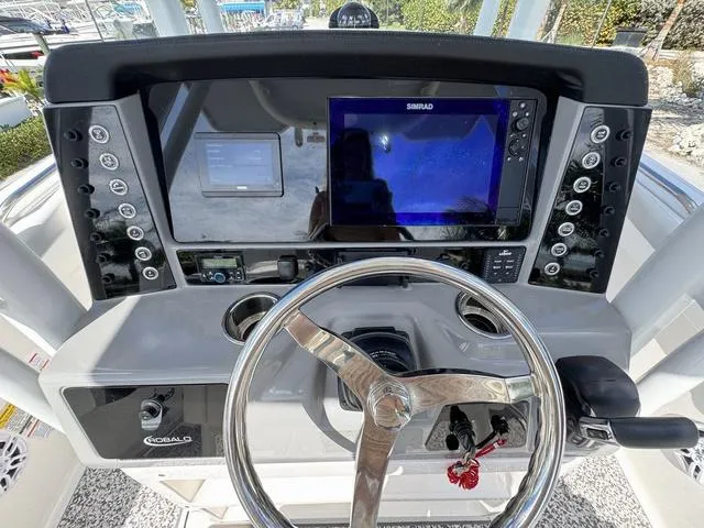 Slide: The Image of 2023 Robalo R230 boat dashboard with steering wheel and navigation system. - 11