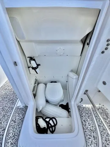 Slide: The Image of 2023 Robalo R230 boat interior with compact marine toilet and storage space. - 15
