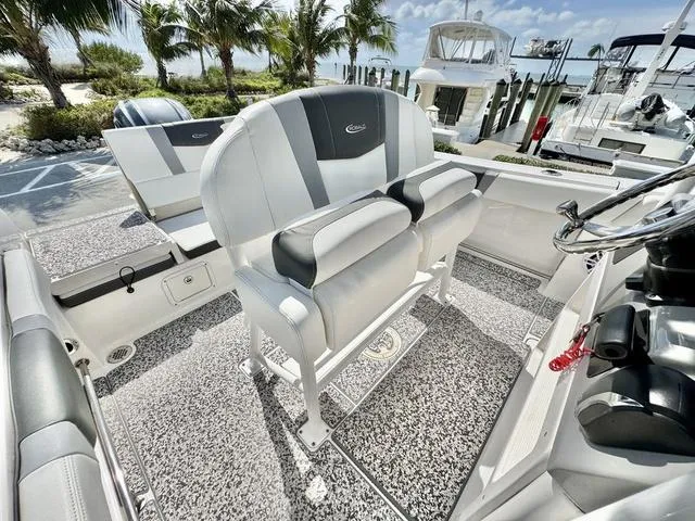 Slide: The Image of 2023 Robalo R230 boat interior with plush seating and modern design at a marina. - 9