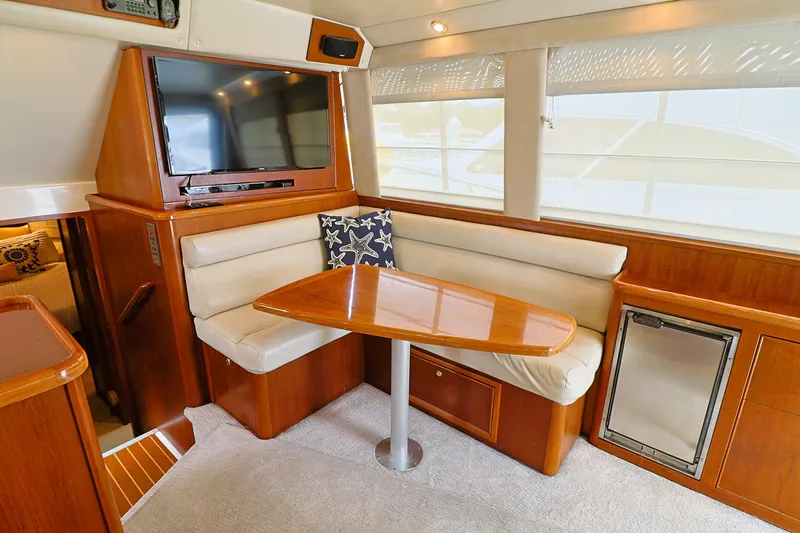 Slide: The Image of Interior of 2000 Riviera Flybridge Convertible yacht with dining area and TV. - 10