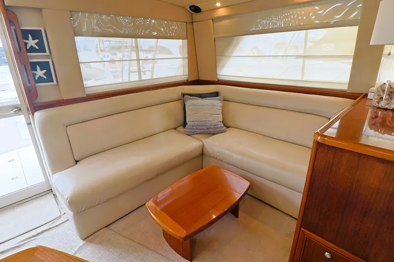 Slide: The Image of Luxurious interior of 2000 Riviera Flybridge Convertible yacht with beige seating and wooden table. - 11