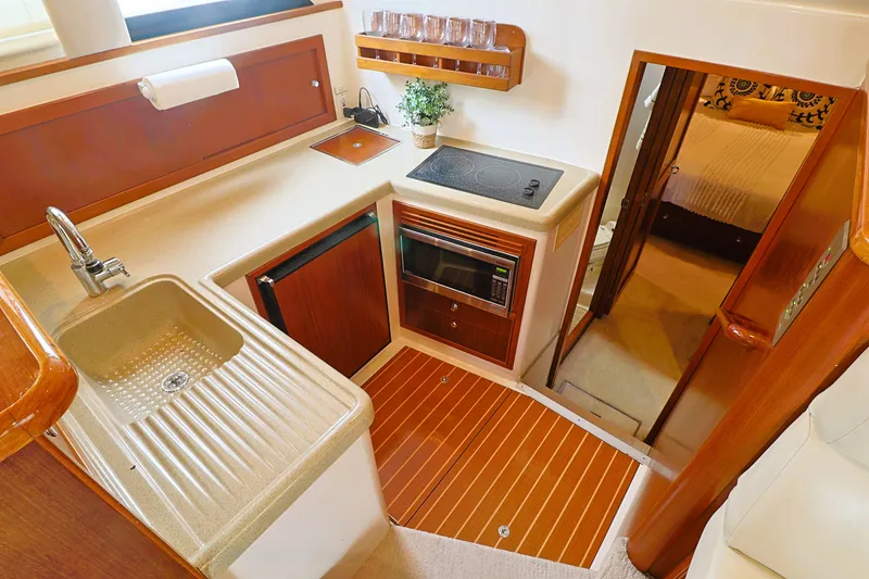 Slide: The Image of Compact kitchen in 2000 Riviera Flybridge Convertible yacht with sink, stove, and microwave. - 13