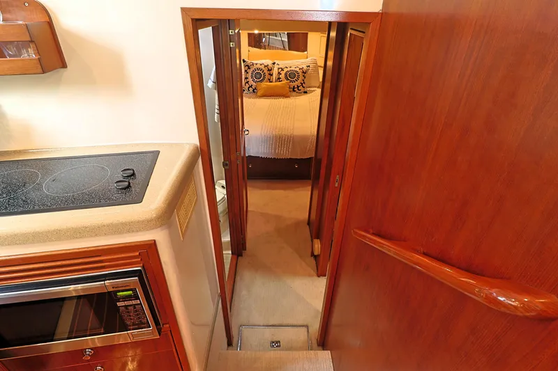 Slide: The Image of Interior of 2000 Riviera Flybridge Convertible yacht with kitchen and bedroom view. - 16