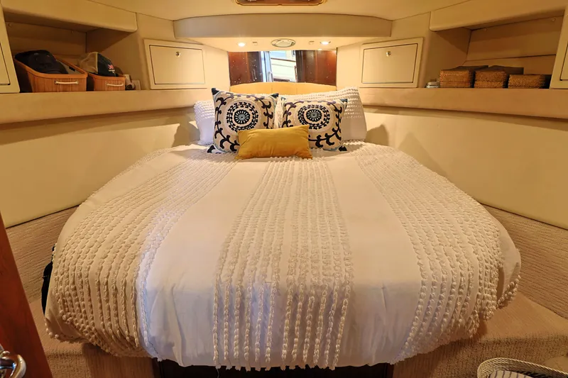 Slide: The Image of Cozy bedroom in 2000 Riviera Flybridge Convertible yacht with elegant bedding and storage. - 18