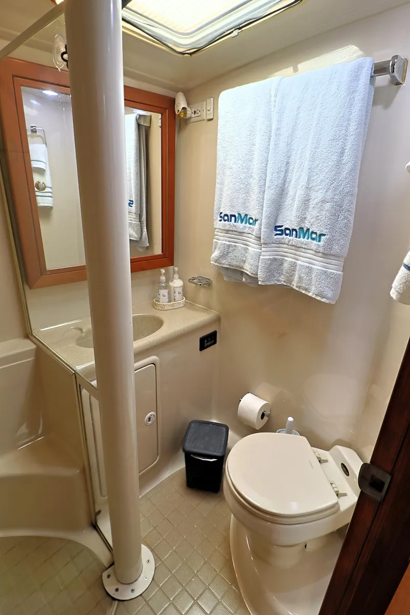 Slide: The Image of Bathroom interior of 2000 Riviera Flybridge Convertible yacht, featuring toilet, sink, and towels. - 20