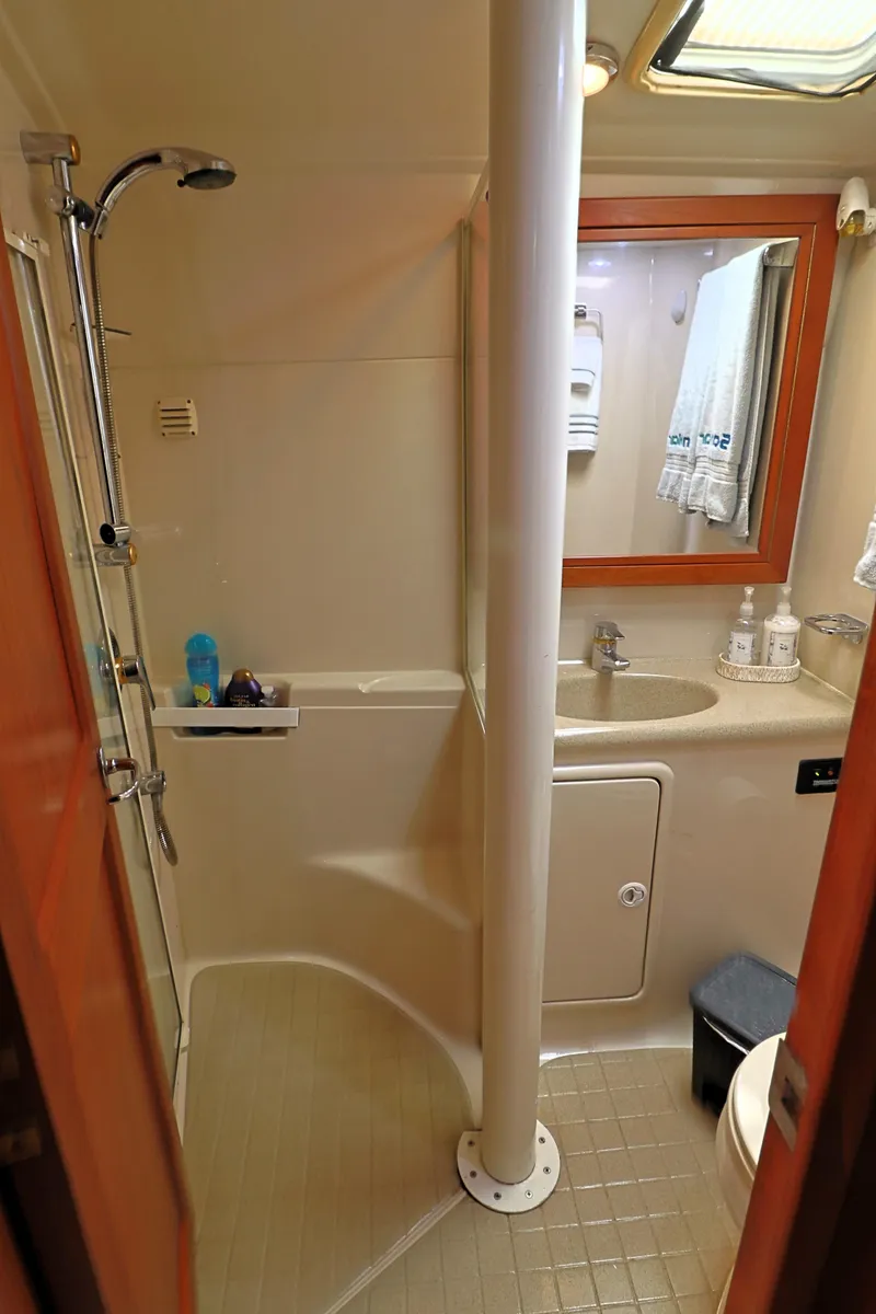 Slide: The Image of 2000 Riviera Flybridge Convertible bathroom with shower, sink, and mirror. - 21