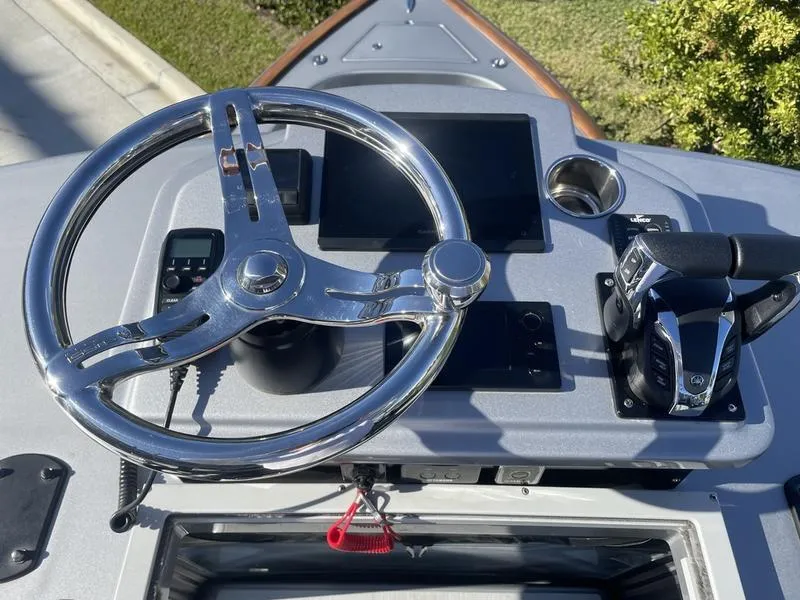 Slide: The Image of Steering console of 2020 Stuart 27 CC boat with chrome wheel and controls. - 12