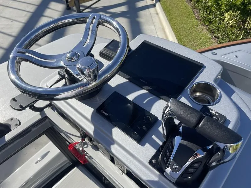 Slide: The Image of Control panel of 2020 Stuart 27 CC boat with steering wheel and electronic displays. - 13