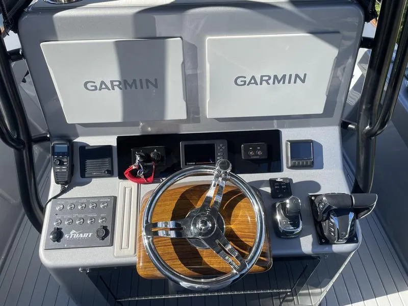 Slide: The Image of Stuart 27 CC 2020 boat dashboard with Garmin displays and steering wheel. - 17