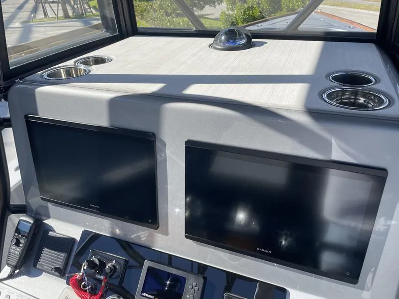 Slide: The Image of 2020 Stuart 27 CC boat dashboard with dual Garmin screens and cup holders. - 18