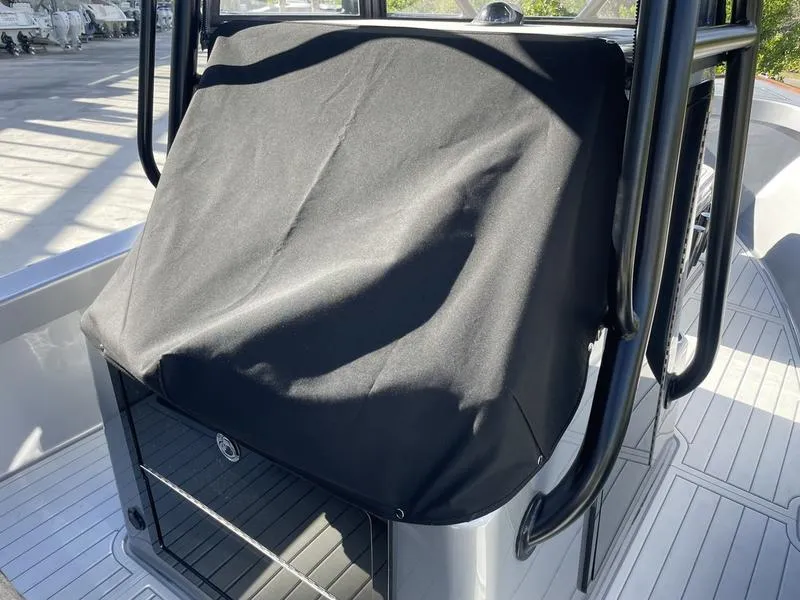 Slide: The Image of 2020 Stuart 27 CC boat console with black cover on deck. - 23