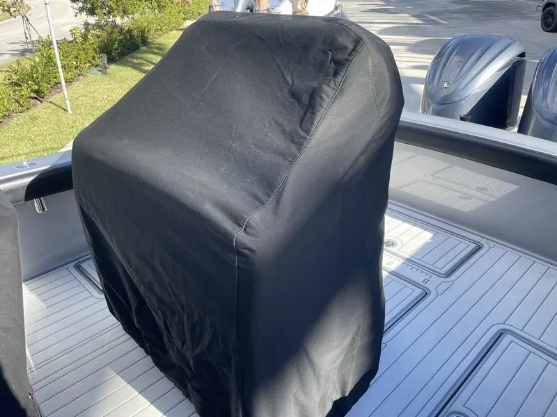 Slide: The Image of 2020 Stuart 27 CC boat console covered, with dual outboard motors visible. - 24