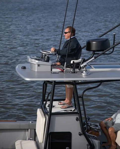 Slide: The Image of Man steering 2020 Stuart 27 CC boat on water. - 3