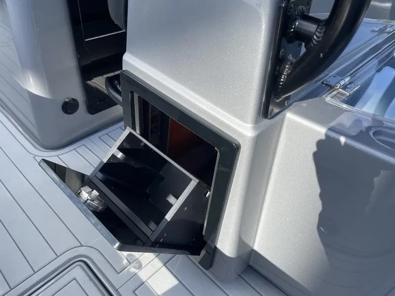 Slide: The Image of 2020 Stuart 27 CC boat console with open storage compartment. - 32