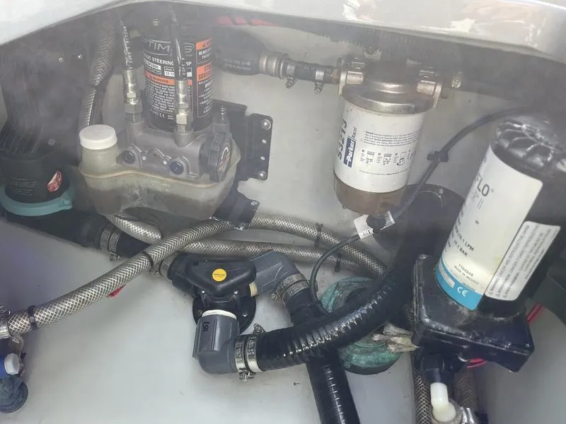 Slide: The Image of Engine compartment of a 2020 Stuart 27 CC boat, showing various mechanical components and hoses. - 35