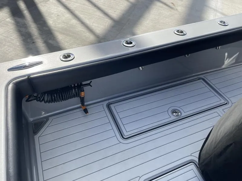 Slide: The Image of 2020 Stuart 27 CC boat deck with rod holders and storage compartment. - 38