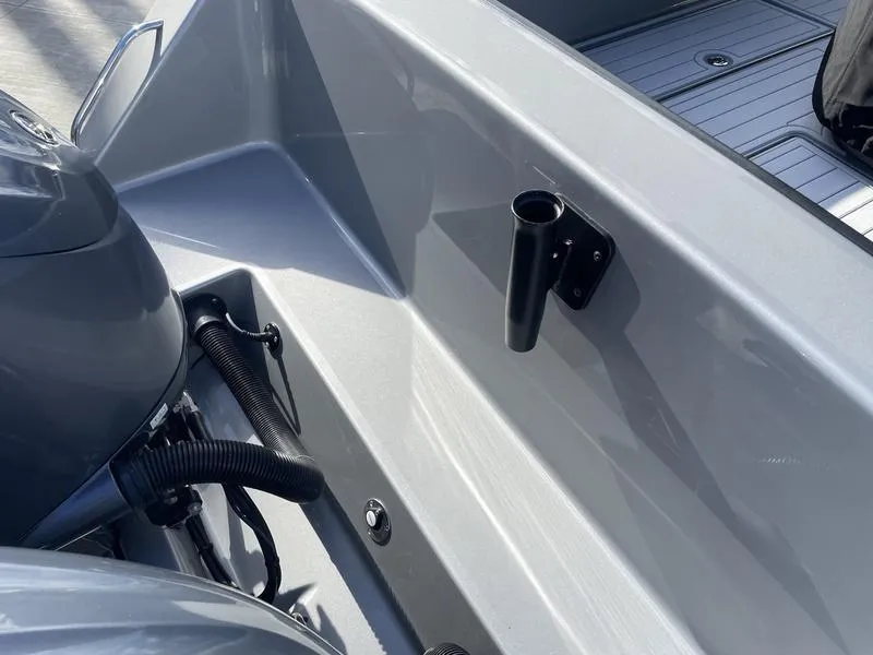 Slide: The Image of 2020 Stuart 27 CC boat interior with rod holder and engine details. - 44