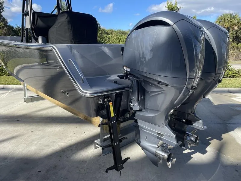 Slide: The Image of 2020 Stuart 27 CC boat with dual outboard motors, parked on a concrete surface. - 47
