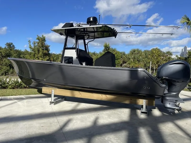 Slide: The Image of 2020 Stuart 27 CC boat on display, sleek design, outdoor setting, clear sky background. - 48