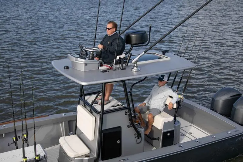 Slide: The Image of 2020 Stuart 27 CC boat on water with two people, fishing rods, and dual engines. - 5