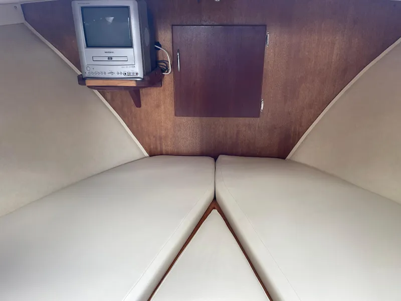 Slide: The Image of 1967 Hatteras 28 Cruiser cabin interior with TV and beige seating. - 10