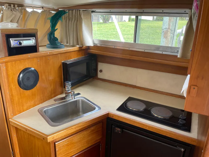 Slide: The Image of 1967 Hatteras 28 Cruiser kitchen with sink, microwave, and stove. - 14
