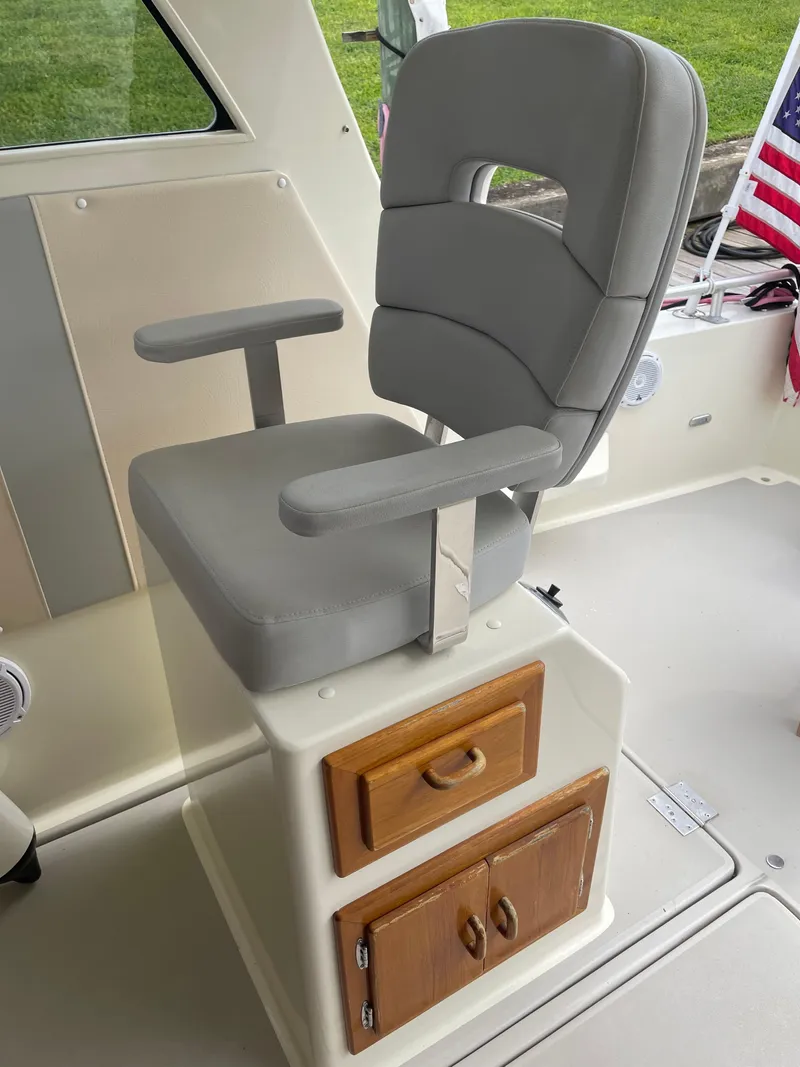 Slide: The Image of Captain's chair on 1967 Hatteras 28 Cruiser with storage drawers, American flag in background. - 28