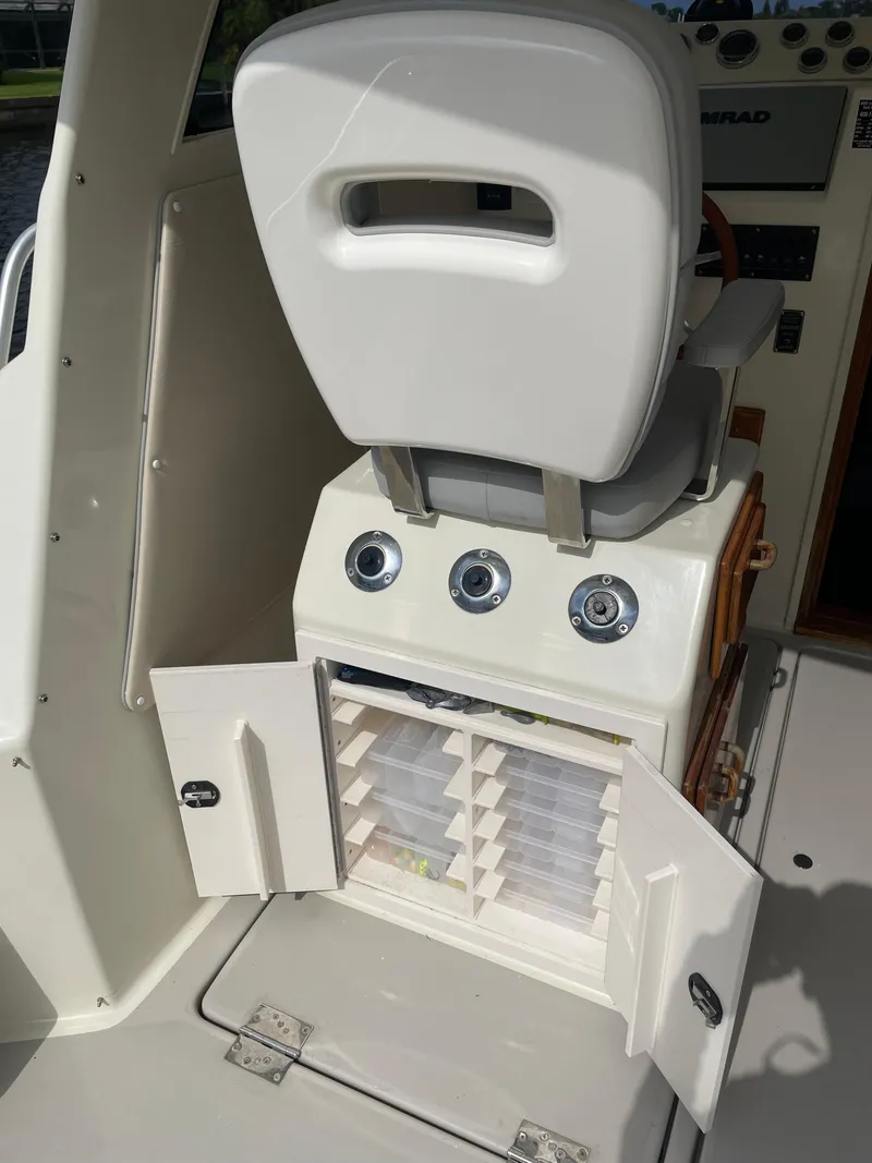 Slide: The Image of 1967 Hatteras 28 Cruiser interior with white seat and open storage compartment. - 36