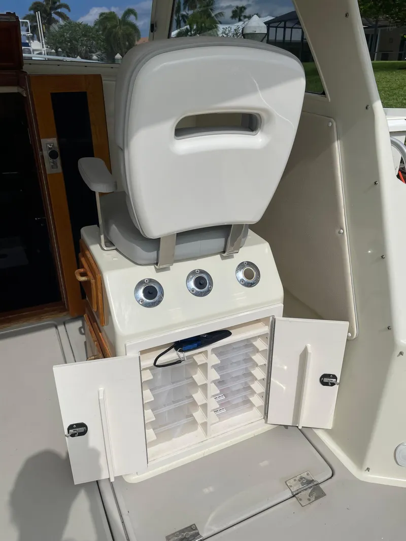 Slide: The Image of 1967 Hatteras 28 Cruiser interior with white captain's chair and open storage compartment. - 37