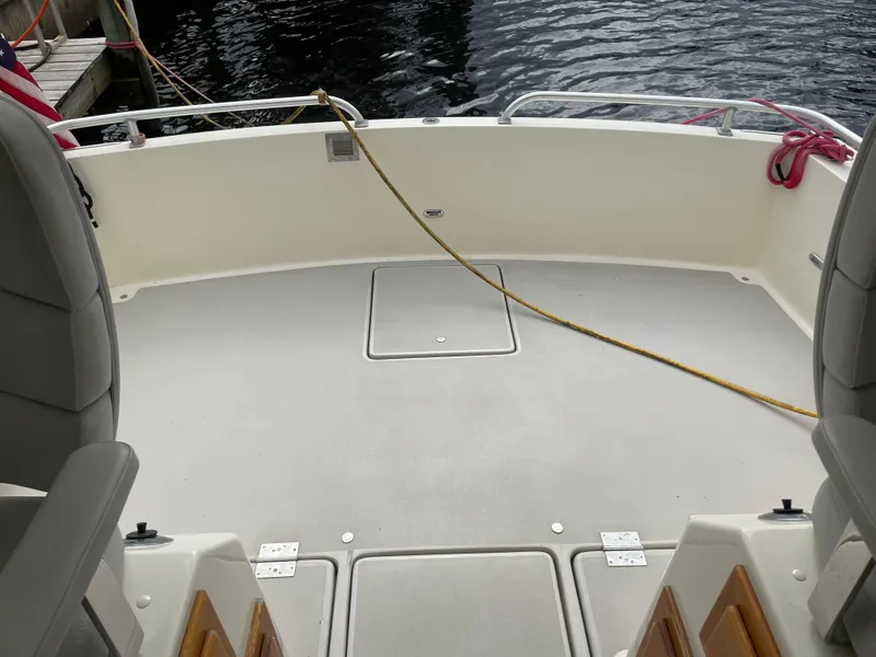 Slide: The Image of 1967 Hatteras 28 Cruiser boat deck with seating, docked by the water. - 38