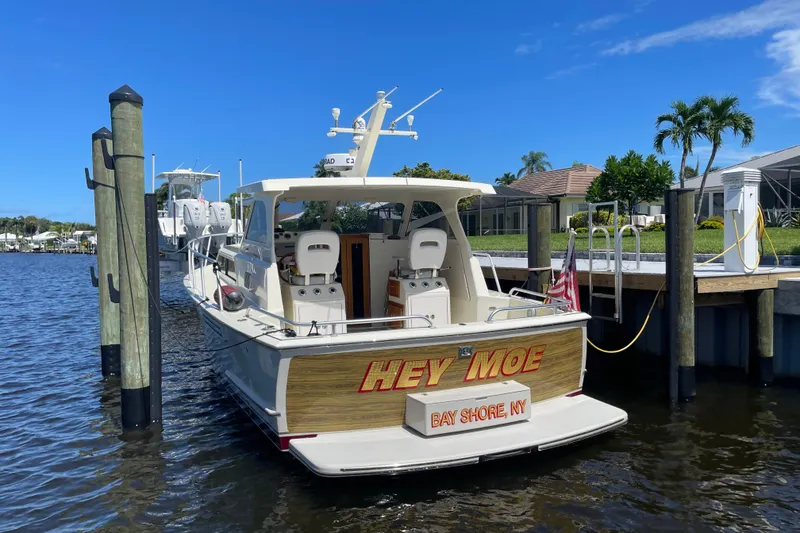 Slide: The Image of 1967 Hatteras 28 Cruiser docked, rear view with "Hey Moe" name, Bay Shore, NY. - 4