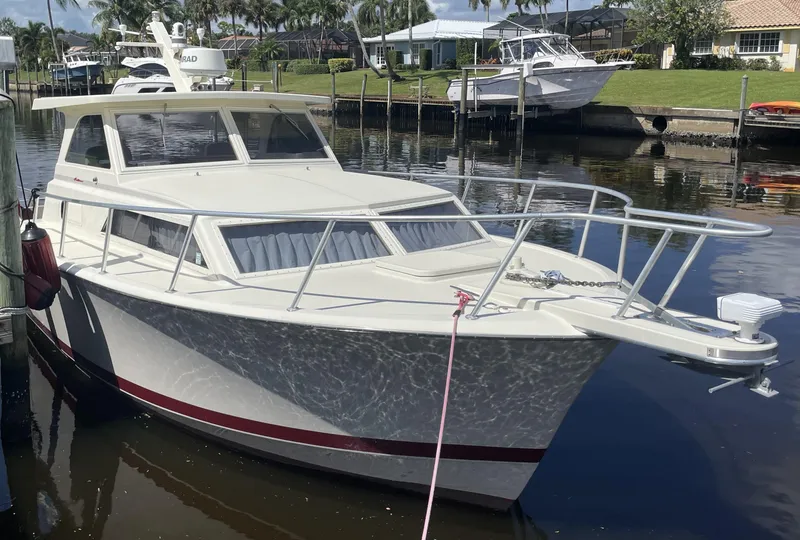 Slide: The Image of 1967 Hatteras 28 Cruiser docked in a marina, featuring classic design and sleek lines. - 5