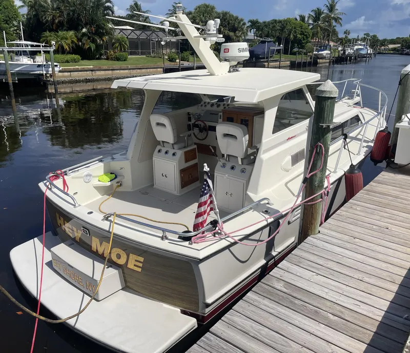 Slide: The Image of 1967 Hatteras 28 Cruiser docked, featuring a classic design and American flag. - 6