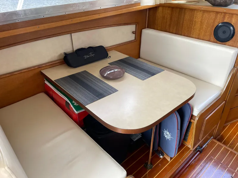 Slide: The Image of 1967 Hatteras 28 Cruiser interior with dining area, wooden accents, and cushioned seating. - 13