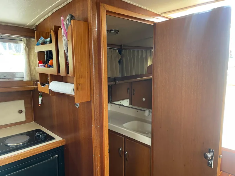Slide: The Image of Interior of 1967 Hatteras 28 Cruiser with wooden cabinetry and compact kitchen area. - 17
