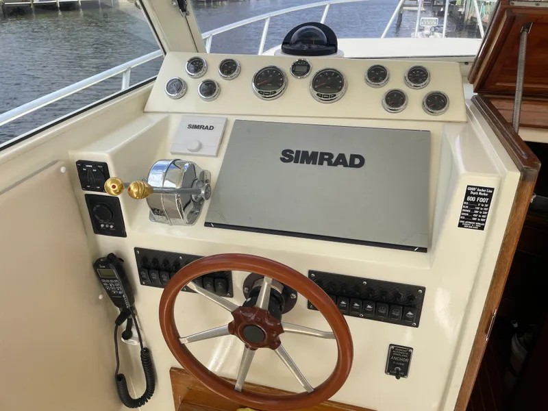 Slide: The Image of 1967 Hatteras 28 Cruiser helm with Simrad navigation system and classic wooden steering wheel. - 29