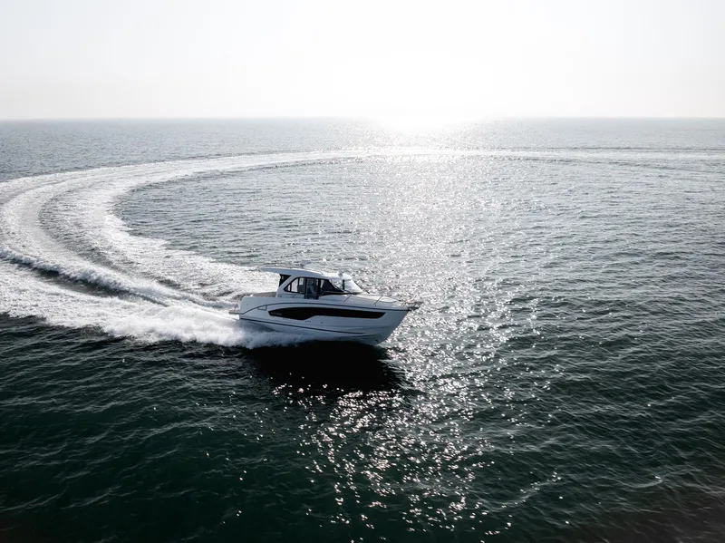 Slide: The Image of 2025 Beneteau Antares 9 cruising on open water, creating a wake under bright sunlight. - 10