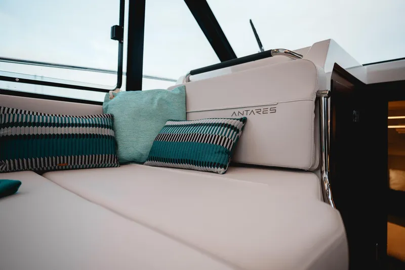 Slide: The Image of 2025 Beneteau Antares 9 interior with stylish cushions and seating. - 12