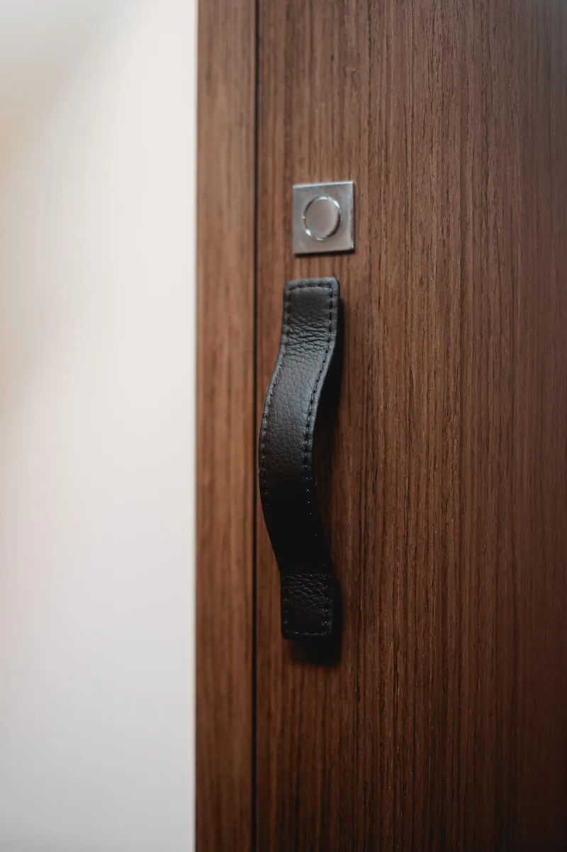 Slide: The Image of Wooden door with a black handle on a 2025 Beneteau Antares 9. - 21