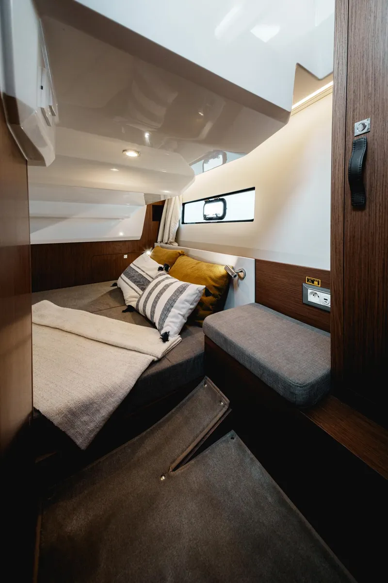 Slide: The Image of 2025 Beneteau Antares 9 cabin interior with cozy bedding and modern design. - 23