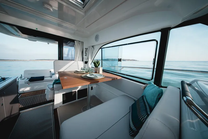 Slide: The Image of Interior of 2025 Beneteau Antares 9 boat, featuring a cozy dining area with ocean view. - 34