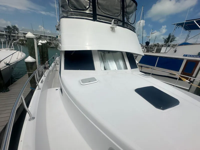 Slide: The Image of 1999 Mainship 430 Trawler docked at marina under clear sky. - 10