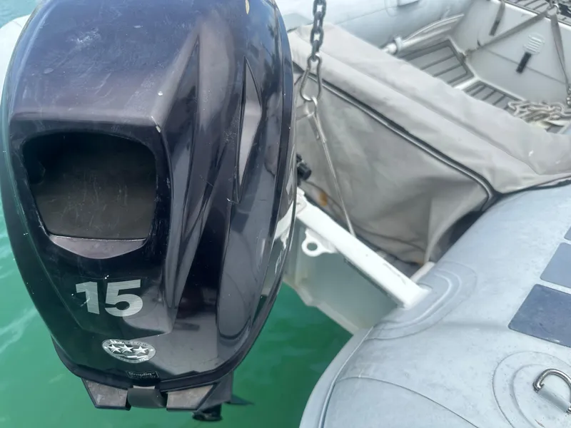 Slide: The Image of Outboard motor on a 1999 Mainship 430 Trawler, docked with inflatable boat. - 16