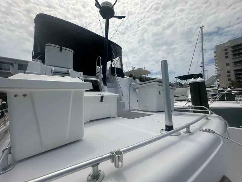 Slide: The Image of 1999 Mainship 430 Trawler on deck, marina background, partly cloudy sky. - 20